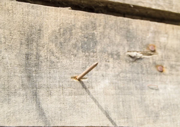 Gros plan de vieux clous rouillés sortant de vieilles planches sombres, texture bois, surface ton vintage — Photo
