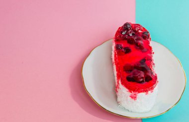 Beyaz bir tabak, pembe ve mavi pastel üst görünümü üzerinde kırmızı krema lingonberries ile güzel bir pasta, kopya alanı