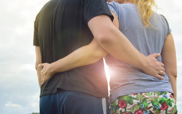 Pareja joven enamorada hombres y mujeres abrazándose contra el cielo, Soleado día de verano en el campo en la naturaleza —  Fotos de Stock