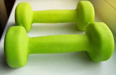 Fitness kavramı, spor için sağlıklı yaşam tarzı-iki yeşil halter, güneş ışığı
