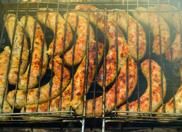 Deliciosas salsichas grelhadas sobre o fogo em um piquenique ao ar livre, close-up, FOOD BACKGROUND — Fotografia de Stock