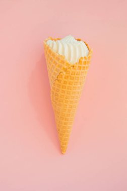 Pembe arka planda waffle koni vanilyalı dondurma, kopya alanı, dikey çekim