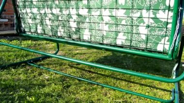 Yaz bahçesinde çim üzerinde sallanan yatak ile modern yeni metal salıncak yatak