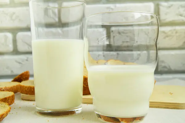 Dois copos de leite estão sobre a mesa, Café da manhã para a família, conceito de alimentação saudável, dia mundial da saúde — Fotografia de Stock