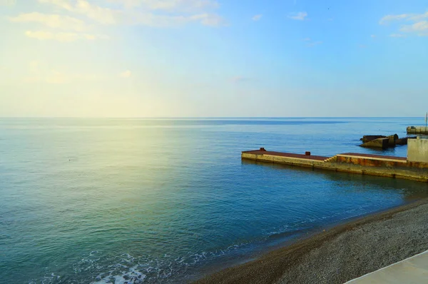 Soluppgång på havet med sol bländning, pir på stranden i tidig morgon, lugn, vila, sommarsemester koncept — Stockfoto