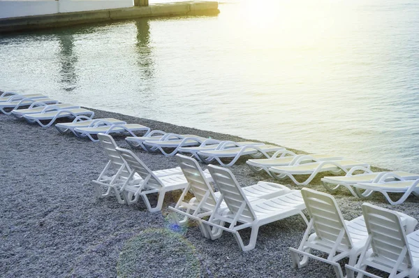 Empty sun loungers by the sea early in the morning, calm, sunrise — Stock Photo, Image