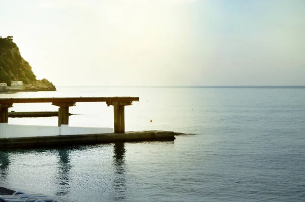 Nascer do sol no mar com brilho do sol, cais na costa no início da manhã, calma, descanso, conceito de férias de verão — Fotografia de Stock