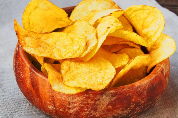 Läckra krispiga potatischips i en gammal träskål — Stockfoto