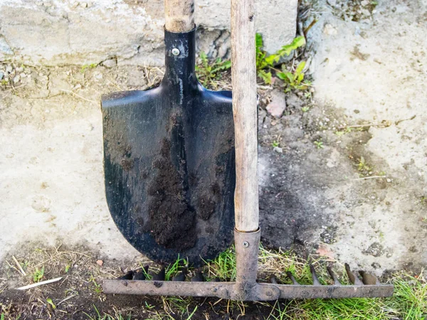 Dos herramientas de jardín sucias y usadas, pala y rastrillo —  Fotos de Stock
