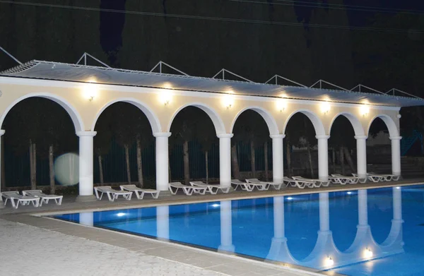 Night view of the luxurious pool with columns and arches, reflected in the water — Stock Photo, Image