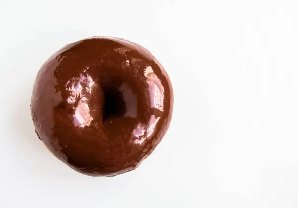 Κοντινό-up του νόστιμο ντόνατ με γυαλιστερό σοκολάτα καθρέφτη γλάσο που απομονώνεται σε λευκό φόντο. Η θέα από την κορυφή — Φωτογραφία Αρχείου