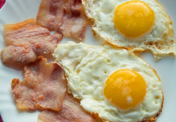 Delicious Breakfast - white plate of fried eggs, bacon — Stock Photo, Image