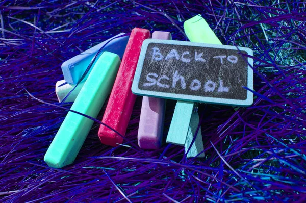 Πίσω στο σχολικό φόντο με πολύχρωμα χρωματιστά μολύβια νέον, σε μωβ λαμπερό φόντο. Επίπεδη θέση, επάνω όψη, αντίγραφο χώρου. Ονειρεμένη μαθήτρια — Φωτογραφία Αρχείου