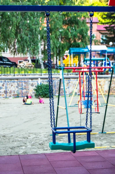 夏の日に公園の遊び場で空のカラフルなプラスチックの赤ちゃんのスイングのクローズアップ — ストック写真