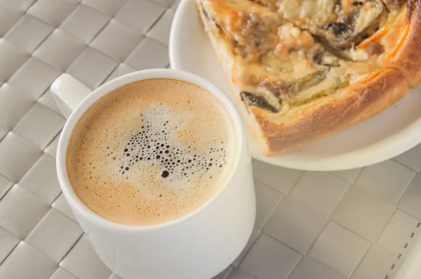 Deliziosa colazione o pranzo con una tazza di caffè e due fette di pizza fresca calda su un piccolo piatto, un tavolo con sfondo grigio — Foto Stock