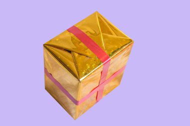 Altın folyo kırmızı kurdele lila arka plan izole ile hediye kutusu sarılı