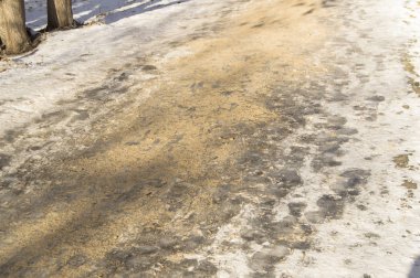 Kaygan kış yolu, Park'ta kaldırım, buzla kaplı ve kum serpilir. Buz üzerinde kaymayı önleyici ve güvenlik
