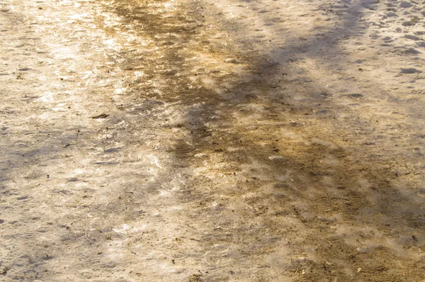 Camino resbaladizo de invierno, acera en el parque, cubierta de hielo y salpicada de arena. Antideslizante y seguridad en el hielo — Foto de Stock