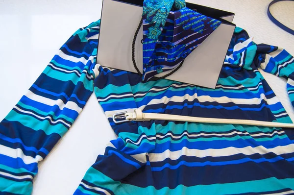 El concepto de comprar ropa y accesorios de moda para mujer, blusa a rayas azul marino, corbata y cinturón aislados sobre fondo blanco — Foto de Stock