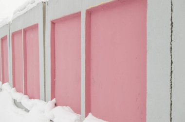 Sokak duvarı, beton levhalar pembe ve beyaz çit, şehirde çit yapımı, kış, yan görünüm
