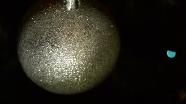 Karanlık bir arka plan üzerinde parlak ve pırıl pırıl bir Noel topu iplik