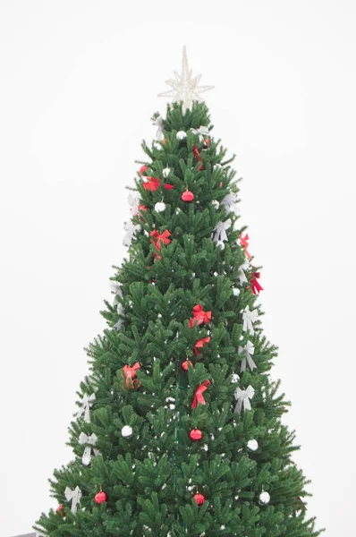 Hermoso árbol de Navidad artificial verde decorado con cintas brillantes y bolas aisladas sobre fondo blanco, tiro vertical — Foto de Stock