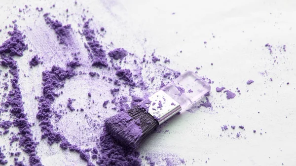 Polvo disperso púrpura con aplicador de cepillo para aplicar maquillaje sobre un fondo aislado blanco, maquillaje de belleza superior — Foto de Stock