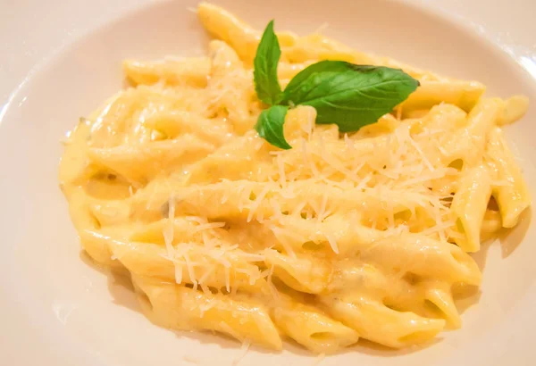 Pasta Penne four cheese with Basil, close-up, traditional Italian recipe, top view — Stock Photo, Image