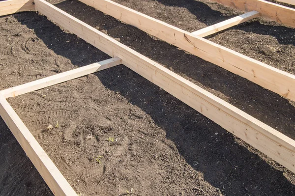 Wooden formwork from new boards for vegetable beds in the garden, preparation and construction, carpentry. — Stock Image Wooden Formwork New Boards Vegetable Beds Garden Preparation Construction Carpentry Stock Image