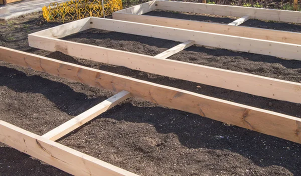 Bahçedeki sebze yatakları için yeni tahtalardan ahşap kaplama, hazırlık ve inşaat, marangozluk.