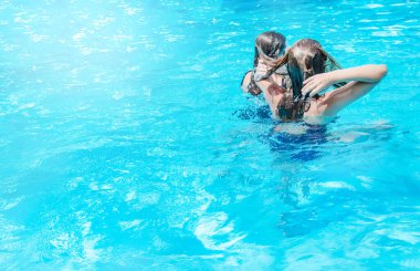 Mutlu kızlar yüzmekten ve havuza dalıp suda dinlenmekten mutlu olurlar..