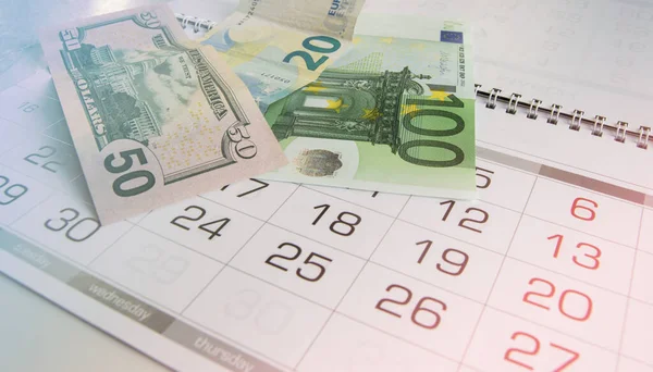 Euro ve takvimdeki dolar banknotları. Vergi raporu, kriz, finans, iş ve planlama.