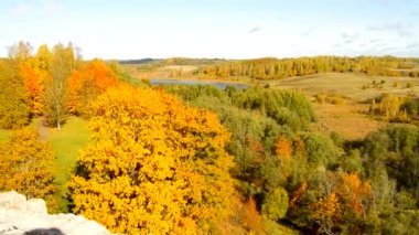 Sarı ağaçlar, tepeler, göl, çayırlar ve evler, Rusya, Pskov, Izborsk