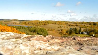 Sarı ağaçlar, tepeler, göl, çayırlar ve evler, Rusya, Pskov, Izborsk