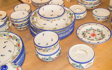 Tezgahta boyalı seramik tabaklar, renkli tabaklar ve kaseler..