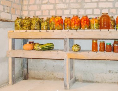 Kilerdeki bir rafta konserve sebze, meyve ve böğürtlen depolamak için cam kavanozlar, organik sebzelerin korunması.