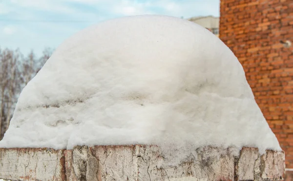 Close up of a large snowdrift on an old brick fence — Stock Photo, Image