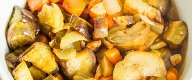 Karışık sebze, patlıcan, soğan ve havuç karışımı bir kasede servis edilir..