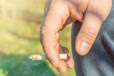 Bir yaz günü, dışarıda sigara içen yaşlı bir adamın yakın çekimi.