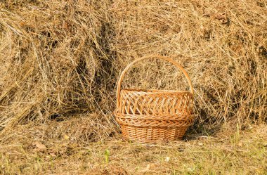 Hasır piknik sepeti ve saman yığını. Güneşli yaz gününde kırsal bir arka plan.