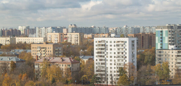 Осенний городской пейзаж - дома на окраине Москвы на закате, небо с облаками и жилыми домами.