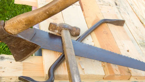 建筑工具锤子 钢锯架 躺在花园的灯板上 — 图库照片