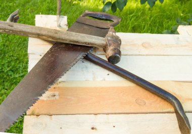 Yapı aletleri çekiç, balta, demir testeresi çerçeve, bahçedeki ışık panolarına uzanır..