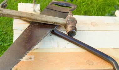 Yapı aletleri çekiç, balta, demir testeresi çerçeve, bahçedeki ışık panolarına uzanır..