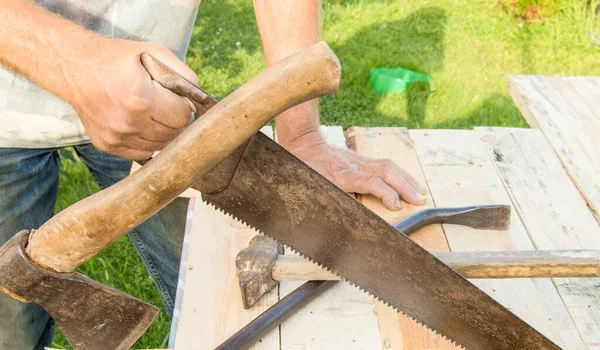 男人在你的花园里用一把锯子 一把斧头 一把铁锤来做建筑工程 — 图库照片