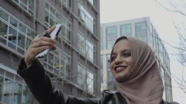 Şehirde selfie yapan türbanlı genç müslüman kız