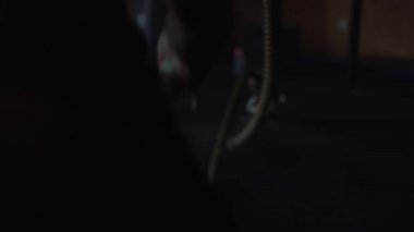 Spor salonunda çapraz fit antrenman yapan adam, halatlarla egzersiz yapıyor