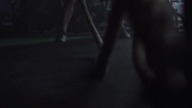 Spor salonunda çapraz fit antrenman yapan adam, halatlarla egzersiz yapıyor