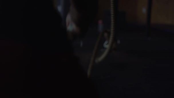 Homme faisant de la musculation au gymnase, des exercices avec des cordes 