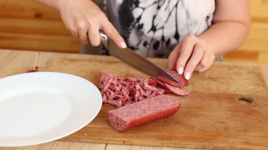 Sosisi bıçakla küçük parçalara ayır. Sosisli salata hazırla..